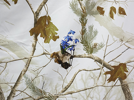 blue flowers on top of a winter camouflage pattern