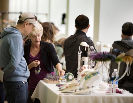 artist talking with customer at market