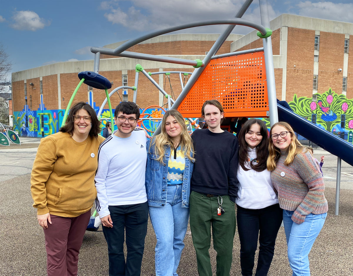 Professor Abby Guido posing with a group of Tyler GAID students outside in an elementary school playground