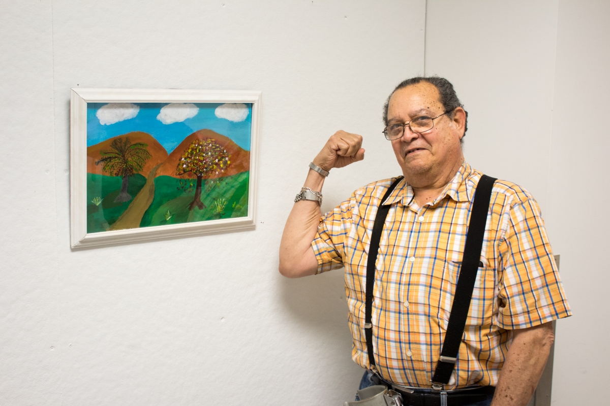 One of the featured artists poses next to their work