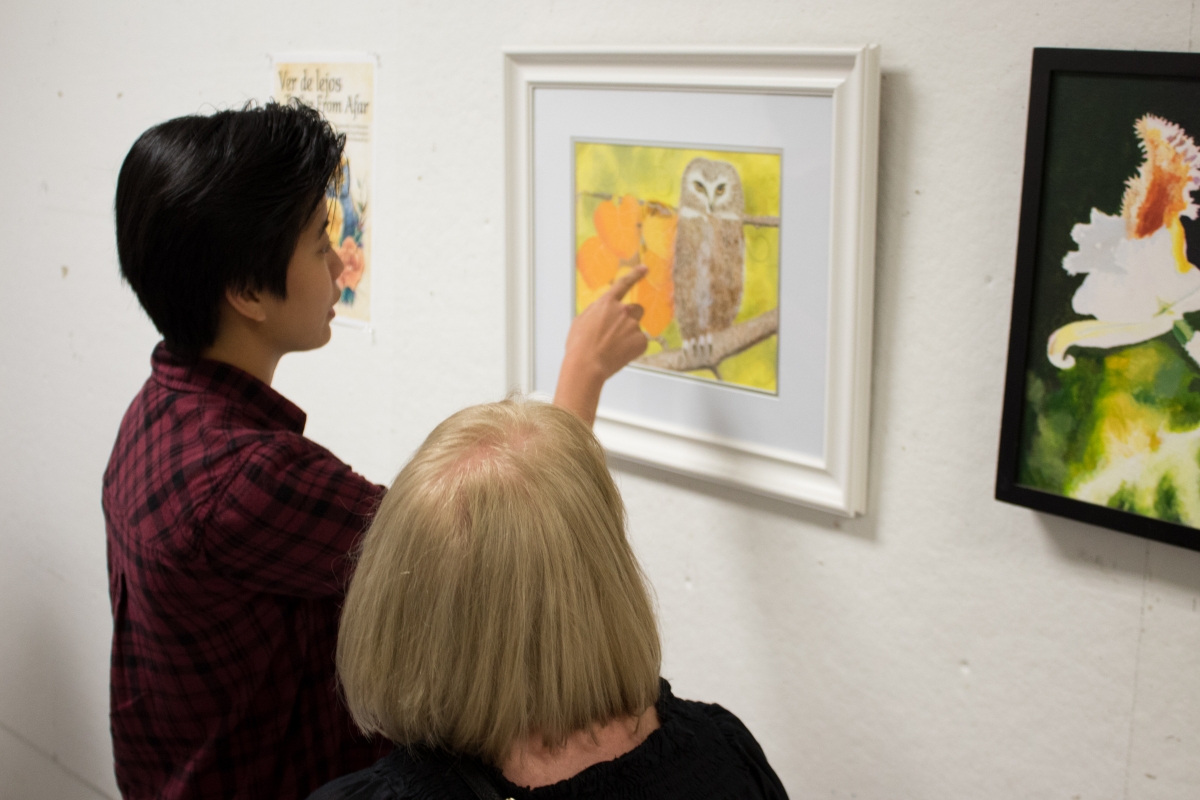 Attendees enjoy the art at the reception