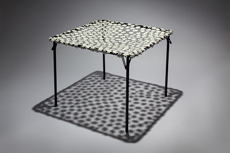 Card table with a sheer floral top.