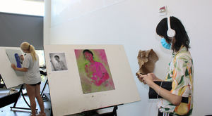Students in a studio painting on easels