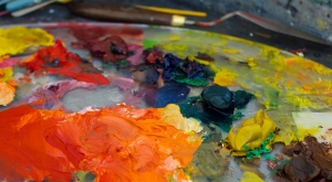 Photo of brightly colored oil paint smears on a painting palette.