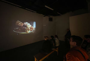 Projection of a video featuring hands peeling a pomegranate