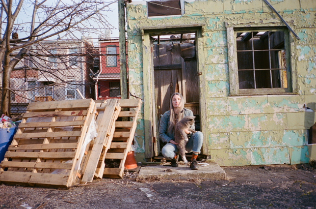 Cynthia Daignault sitting outside a building holding a cat