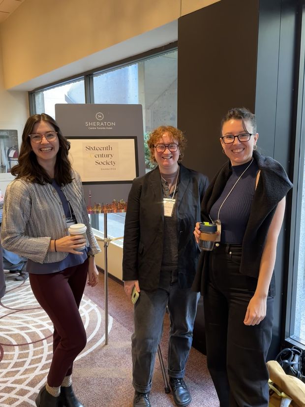 Emma Holter, Ana Matisse Donefer-Hickie, and Jackie Streker posing in front of a poster