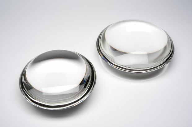 Two clear glass discs against a white background