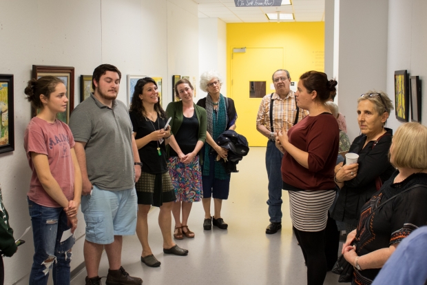 Art Educator Jamie Forslund gives talk to attendees at reception for Ver de lejos Exhibition