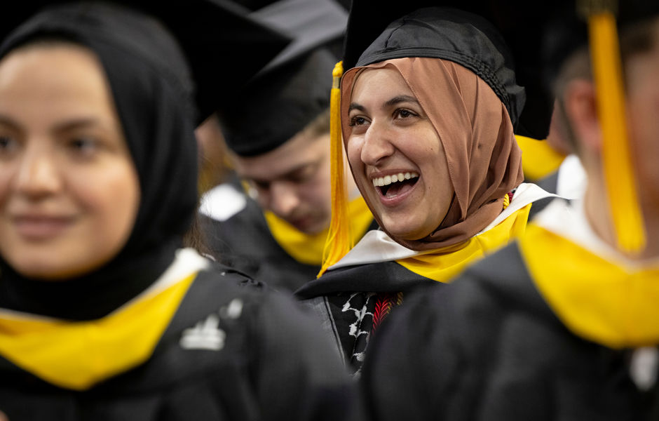 A graduate smiling in the crowd