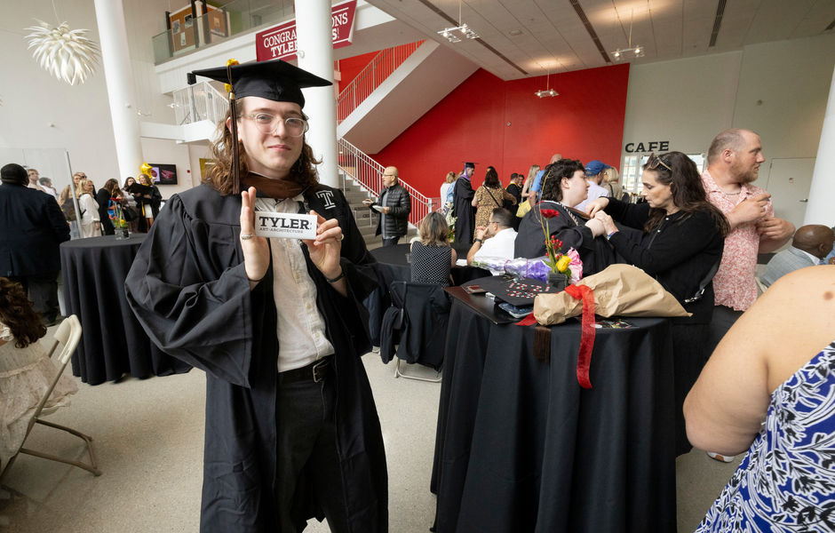 A graduate holds up a Tyler chocolate bar at the pre-graduation ceremony