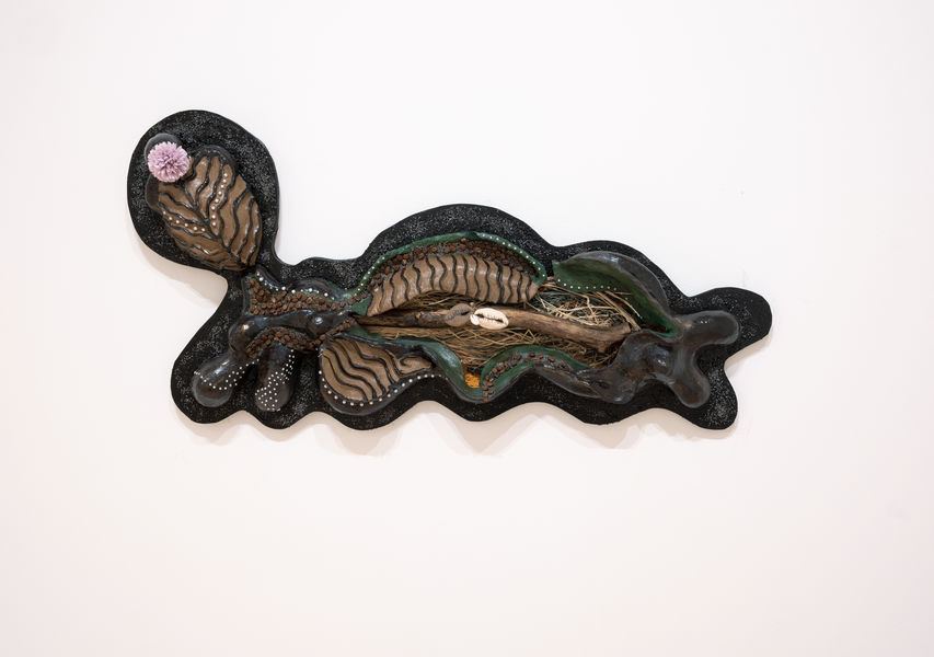 Ceramics artwork by Anne Adams with tree branch, coffee beans, cowries, raffia, dyed sand, flower, pearls, and wood elements