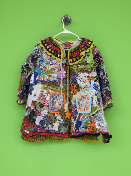 Elaborate and colorful fiber arts piece by Kara Anstine hanging against a bright green wall