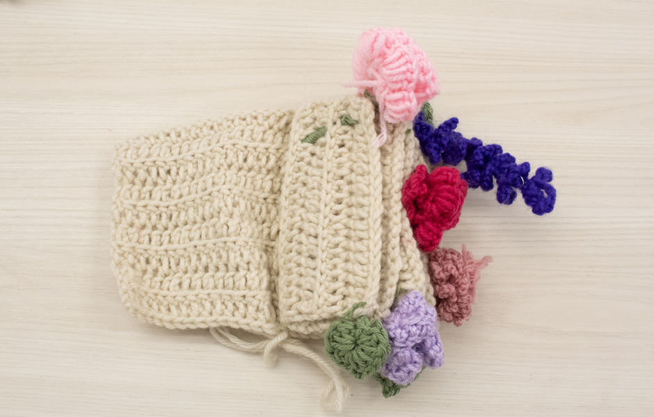Crocheted book cover with crocheted flowers coming out