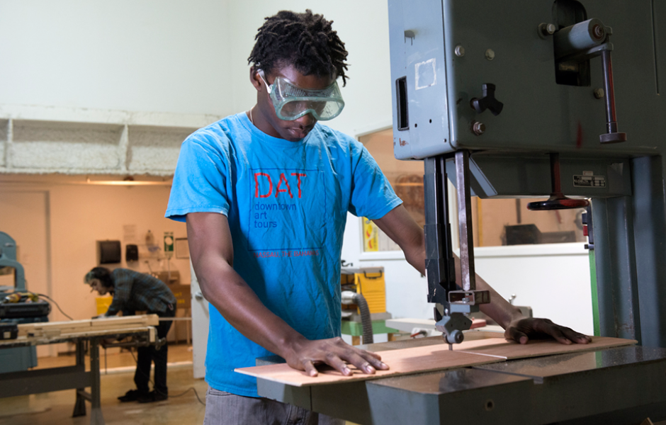 student uses bandsaw to work on sculpture project