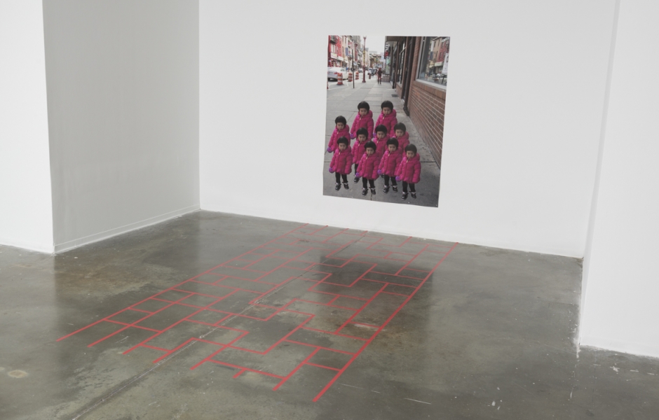 Red tape in Chinatown sidewalk pattern on the floor with a large digital photo print of a little Chinese girl repeated.