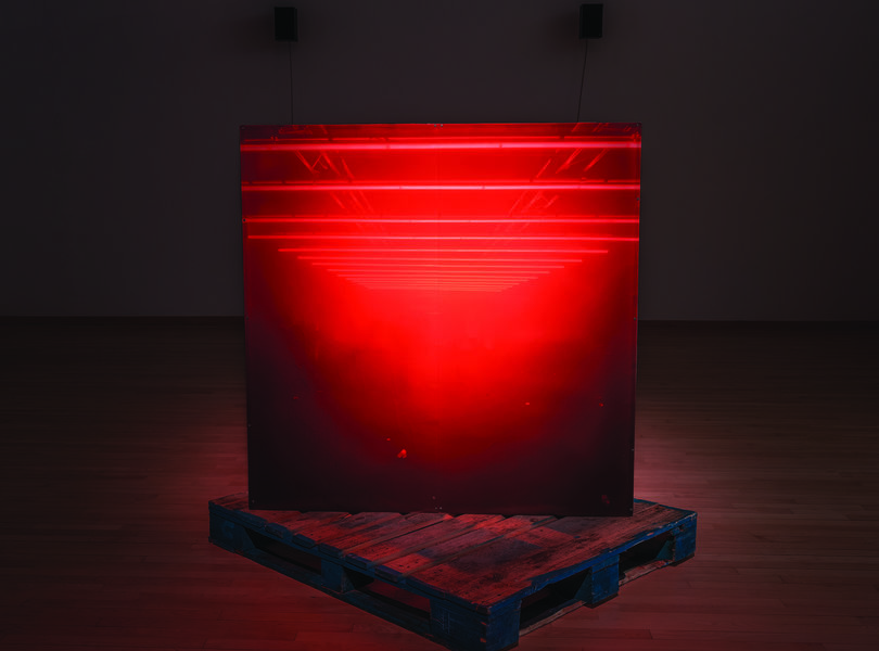 Glowing red large-print photograph, placed on top of a wooden pallet