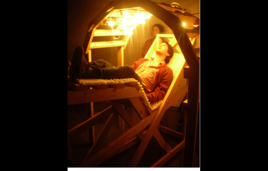 A student sits inside a relaxation chamber sculpture