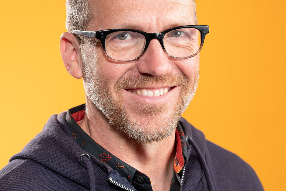 Brian Biggs headshot Brian Biggs smiling with yellow background