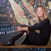 Paula Scher sits in front of a map that she designed