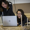 Two architecture students smiling at a computer as they work together