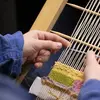 Student using a hand loom for weaving
