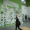 student walking past a collection of art education work