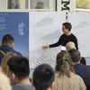 Two people presenting an architectural drawing to a group