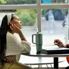two students sitting at a table by a window