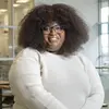 Tomie Wilson standing in the Tyler lobby and smiling at the camera