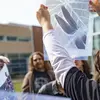 Student holding up a transparent photographic print outdoors