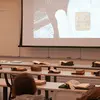 Art history instructor showing a detail of an object on a screen to a class