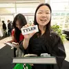 Smiling graduate holding a candy bar with the Tyler logo