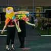 Students wear soft sculptures over their heads and walk down a fashion runway in Tyler's outdoor courtyard