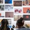 Two people looking at a wall of photographs in a gallery