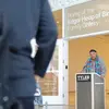 Edgar Heap of Birds speaking at a podium in front of Temple Contemporary gallery