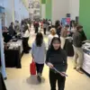 attendees walk down the atrium amongst tables for the AED Career Fair