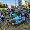 Group of adults and children standing or seated at picnic tables participating in an art project