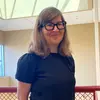 Kathy Peters standing indoors and smiling at the camera