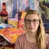 Portrait of Lauren Whearty in front of a painting