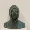 ceramic bust of a person in a hood