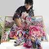 Artist Co.ette Fu holding a large, colorful pop-up book