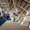 People looking at a wooden architectural model