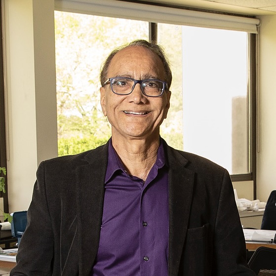 Baldev Lamba smiling at the camera.
