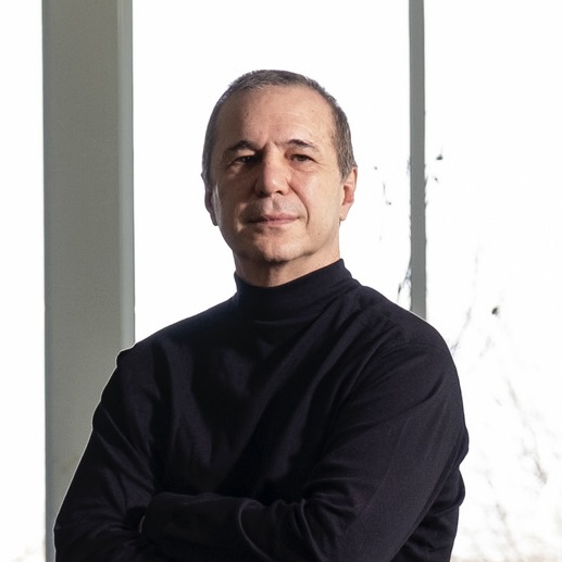 Pablo Meninato, with his arms crossed looks at the camera in an architecture studio space.