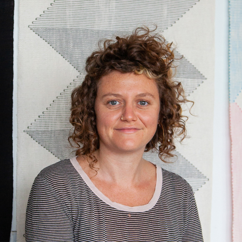 Lena Kolb standing in front of large fibers art work